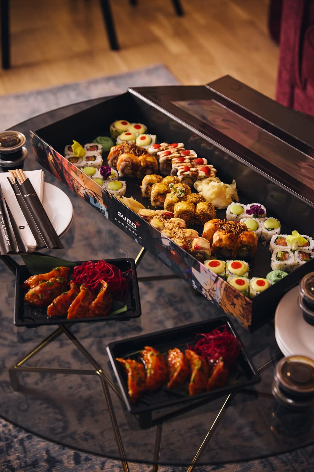 Sushi og varmretter servert på et mørkt bord