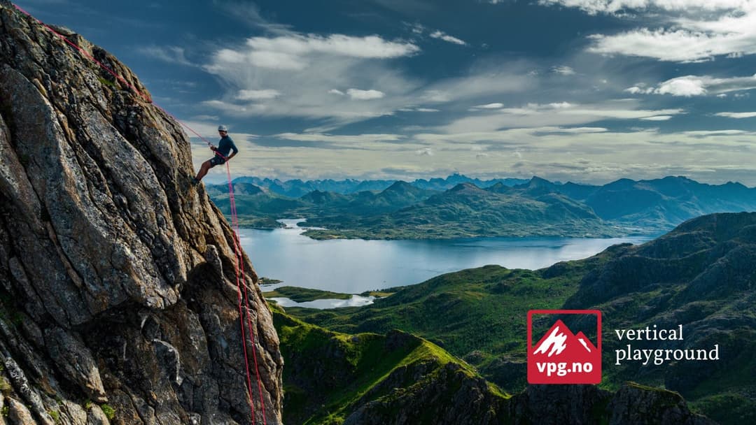 Klatrer på en fjellvegg over et fjordlandskap, med logoen til Vertical Playground